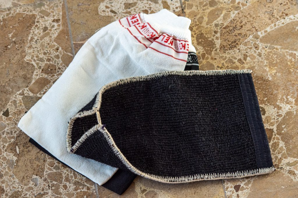 traditional wool and silk scrubbing glove and two cheaper nylon variants