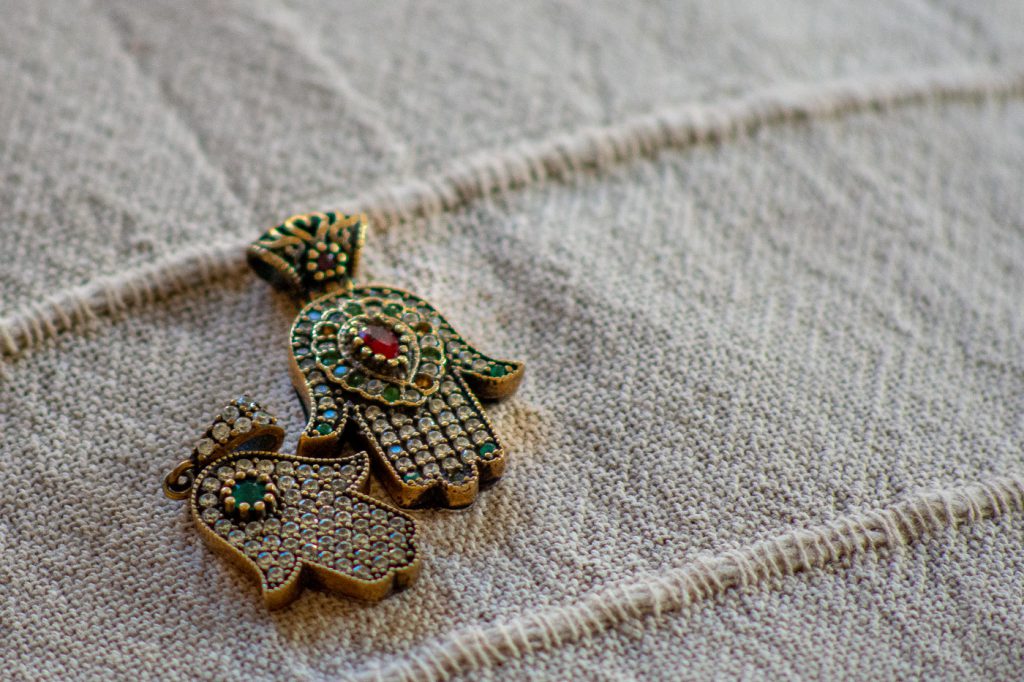 two silver hamza pendants
