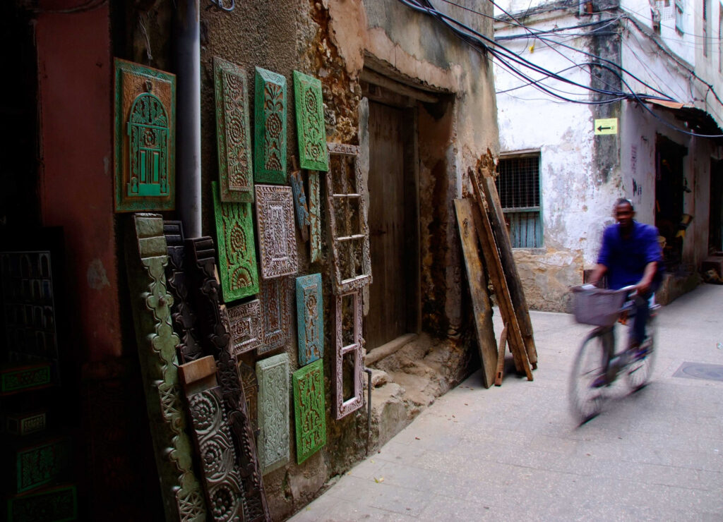 A cyclist passing through the narrow alleys of Stone Town, Tanzania